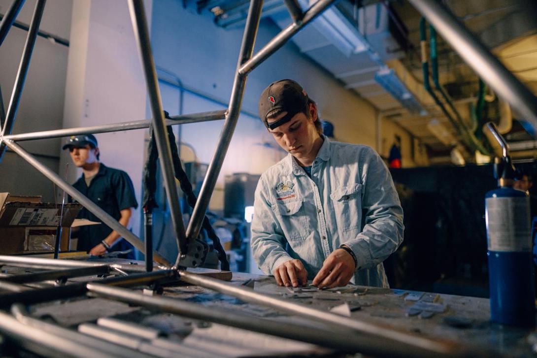 student working on car parts